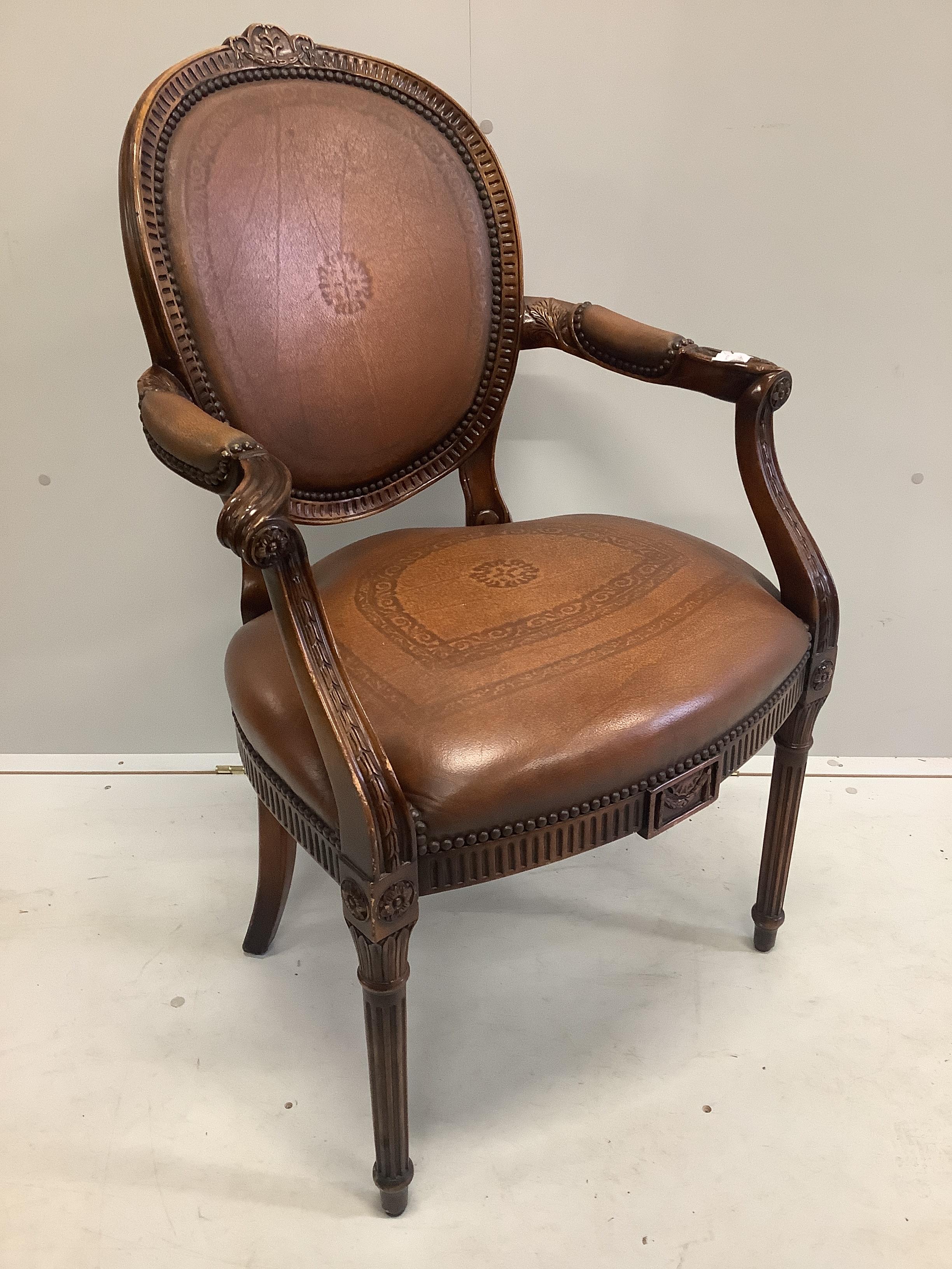 A Theodore Alexander mahogany and embossed tan leather elbow chair, width 61cm, depth 50cm, height 100cm